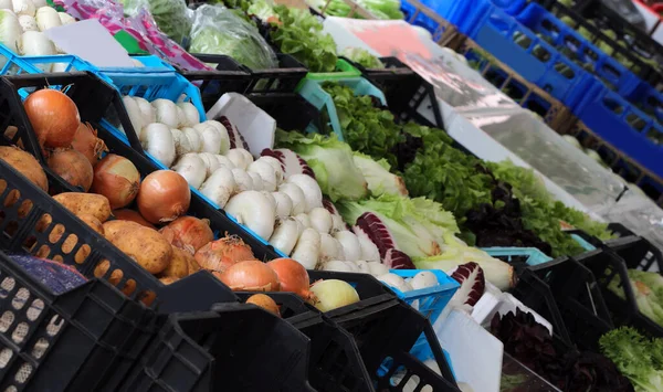 Cassette di cipolle e ortaggi e frutta nella stalla del fr — Foto Stock
