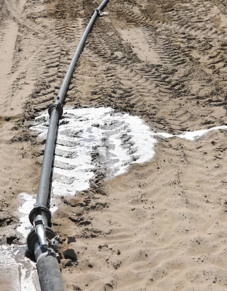 Tubo de um sistema de irrigação com perda de água no solo — Fotografia de Stock