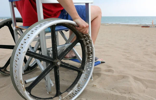 Ragazzo disabile in una sedia a rotelle speciale per spostarsi facilmente nel san — Foto Stock