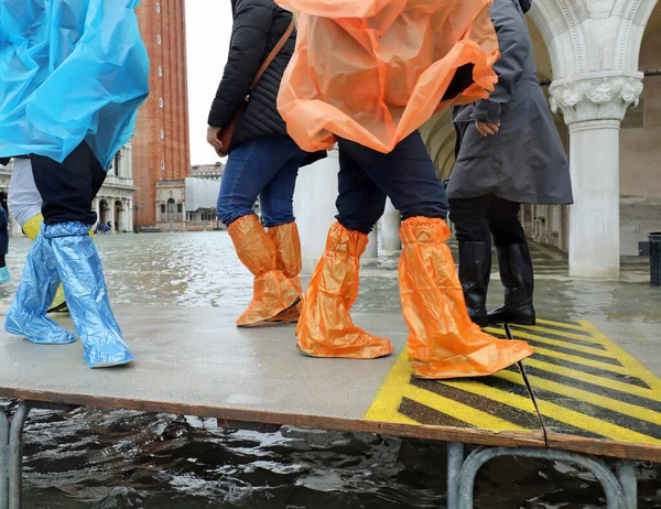 Moving people with plastic leggings on the footbridge in Venice — Stock Photo, Image