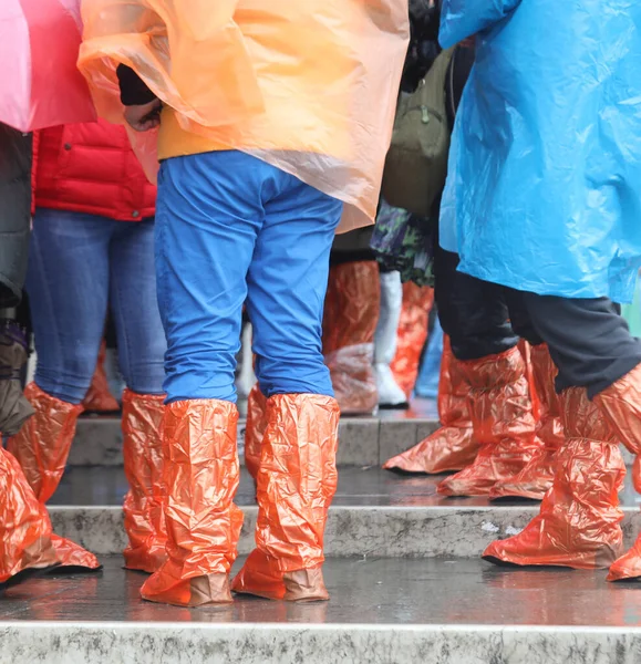 Pessoas com casacos de chuva e leggings de plástico especiais de fiação floo — Fotografia de Stock