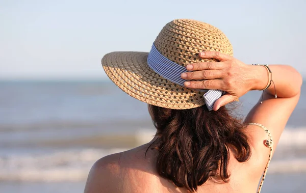 Frau mit Strohhut am Meer im Sommer — Stockfoto