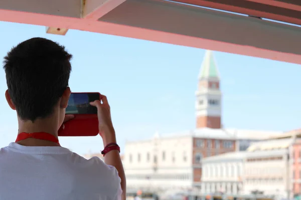少年はベンのボートからセントマークの鐘楼で写真を撮る — ストック写真