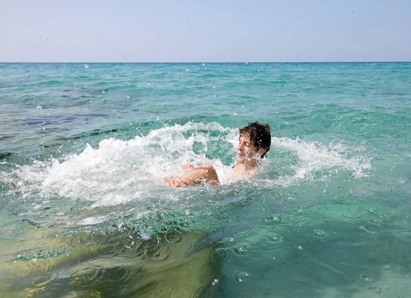 Chlapec se ponoří pozpátku do čistých vod moře — Stock fotografie