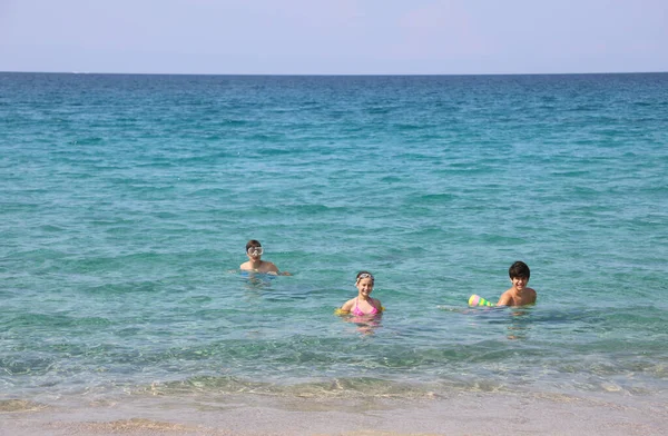 Два мальчика и маленькая девочка на воде океана — стоковое фото