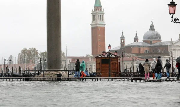 Pessoas na passarela na Ilha de Veneza, na Itália, durante a maré — Fotografia de Stock