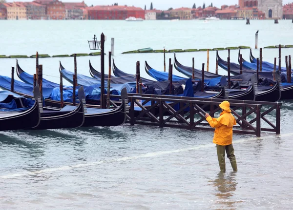 Mann mit wasserdichter Kleidung und den Gondelbooten in Venedig — Stockfoto