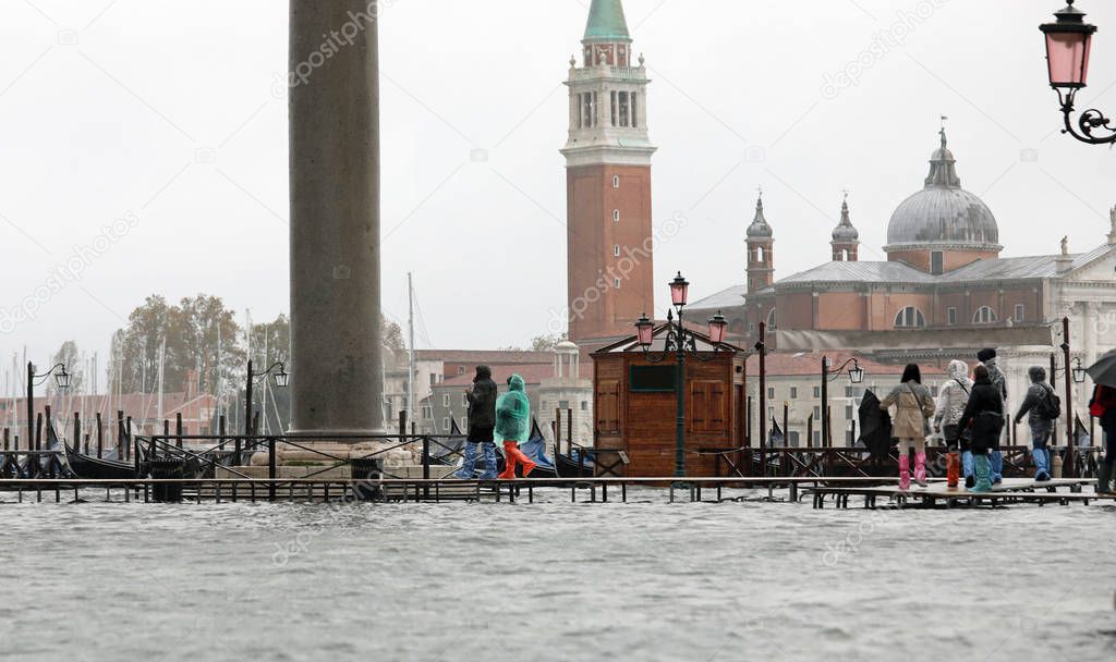 people on the walkway in Venice Island in Italy during the tide