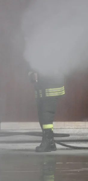 Πυροσβέστης χρησιμοποιεί πυροσβεστικό κρουνό για να σβήσει φωτιά — Φωτογραφία Αρχείου