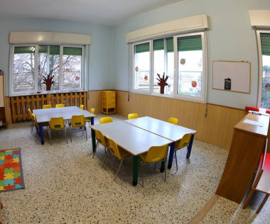 Renkli sandalyeli ve küçük çocuksuz okul sınıfı.