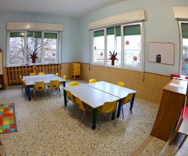 Renkli sandalyeli ve küçük çocuksuz okul sınıfı.