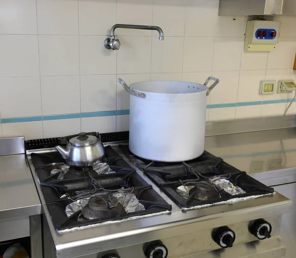 Pot over the gas stove and a teapot in the stainless steel kitch — Stock Photo, Image