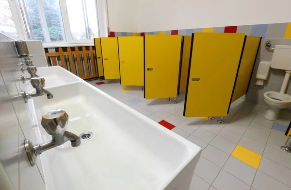 Grifos de lavabo y puertas amarillas en el baño de una guardería — Foto de Stock