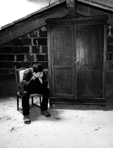 Hombre triste en el ático y un viejo armario de madera — Foto de Stock
