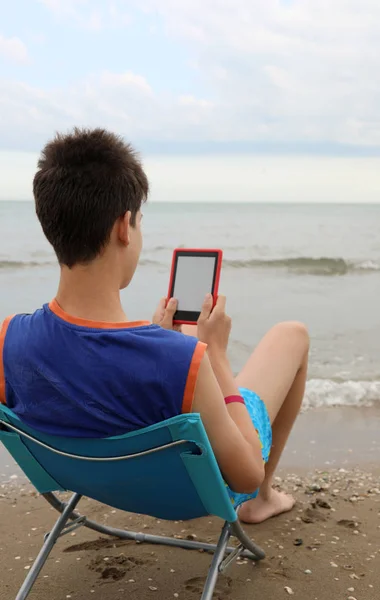 若い男の子は夏にビーチで電子ブックを読みます — ストック写真