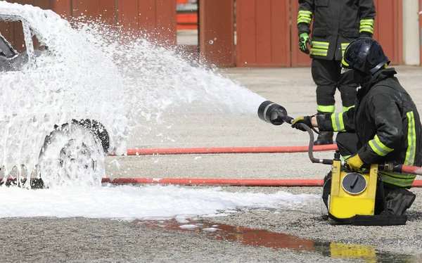 Feuerwehrmann löscht Brand, der in Auto ausgebrochen ist — Stockfoto