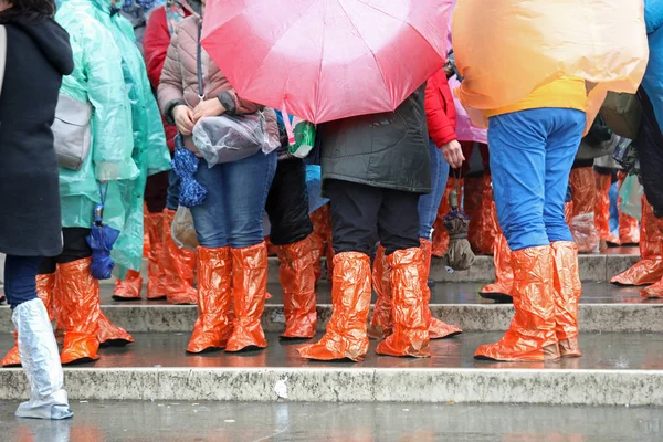 Menschen mit Gamaschen und regendichten Regenmänteln und Regenschirmen — Stockfoto