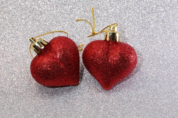 Red glitter hearts on glittering silver glitter background — Stock Photo, Image