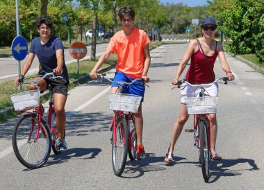 Annem ve kardeşlerim bisiklete biniyor.