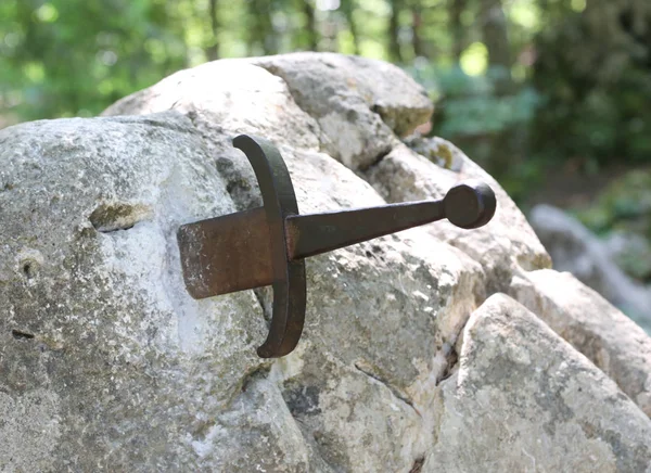 Espada del Rey Arturo llamada Excalibur atascada en la roca en el frente — Foto de Stock