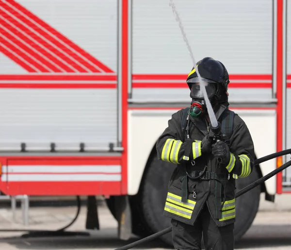 Fireman with hose hydrant — Stok fotoğraf
