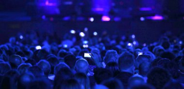 many people with modern mobile phone at live concert