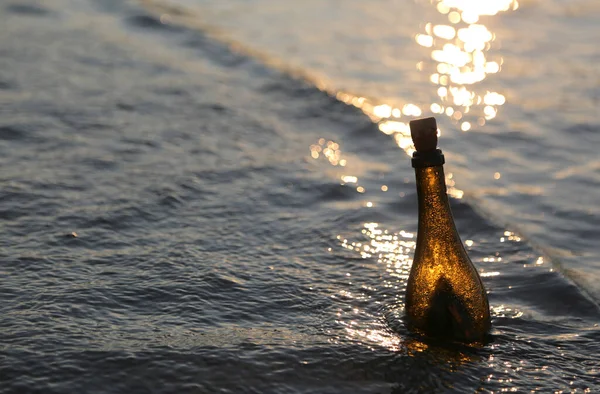 Üveg a titkos üzenetet a tengerben a napsütésben — Stock Fotó