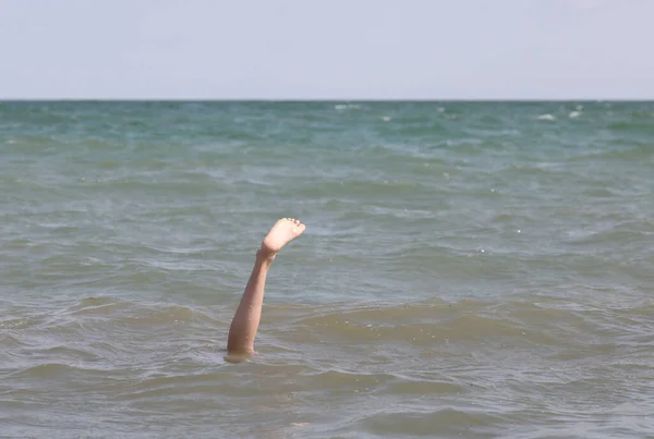 Foot and leg of young boy on the ocean — Stock Photo, Image