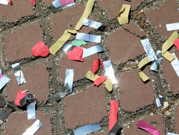 Kleurrijke confetti verspreid over het asfalt na een carnaval para — Stockfoto