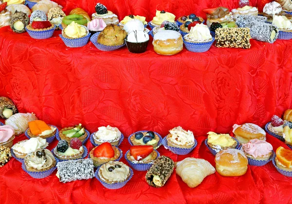 Pastries on top of the red tablecloth — 스톡 사진