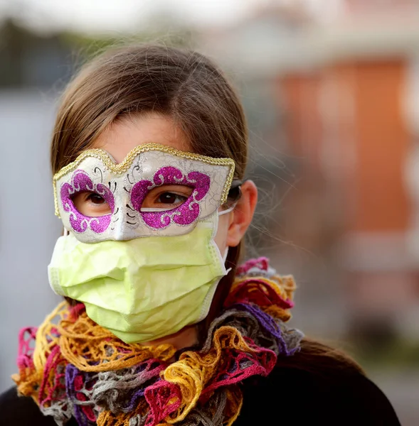 Young girl with health mask and carnival mask for protection against the Virus crown