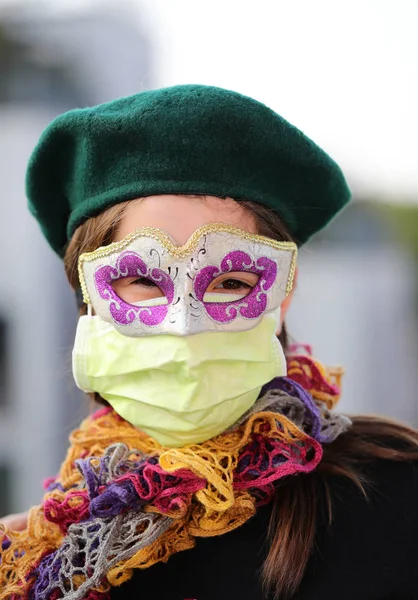 Young girl with health mask and carnival mask for protection against the Virus crown