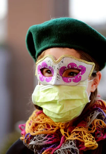 Young girl with health mask and carnival mask for protection against the Virus crown