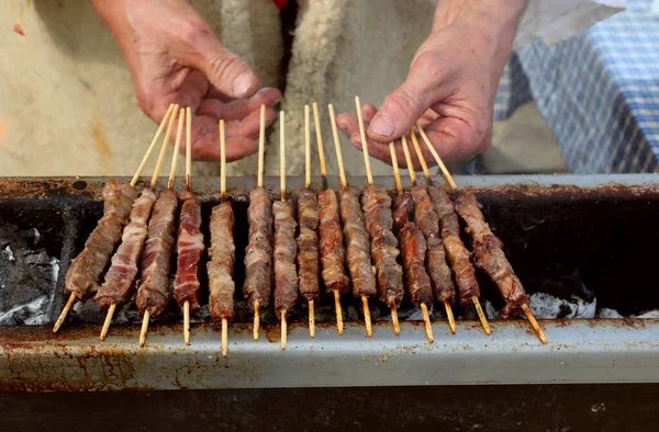 厨师的手 厨师用意大利语煮羊肉串叫Arrosticini — 图库照片