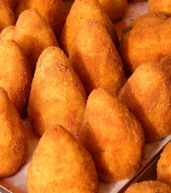 fried stuffed balls of rice called ARANCINO in Italian Language for sale at the street food stall clipart