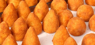 İtalyan dilinde Arancino isminde kızarmış top pirinci Güney İtalya 'daki sokak yemekleri standında satılıyor.