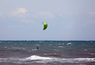 Yazın uçurtma düşerken okyanusta bir adam
