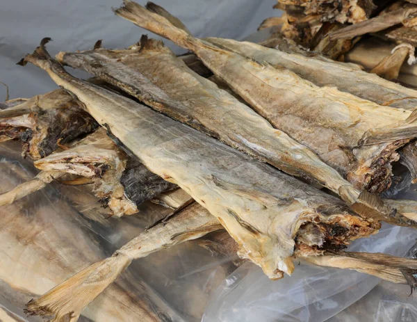 many dried cod type fish on sale in the stall of fish specialties