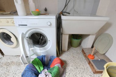 Çamaşır odasında iki çamaşır makinesi ve bir lavabo.