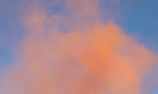 濃いオレンジ色の煙が立ち上がり青空の背景には — ストック写真