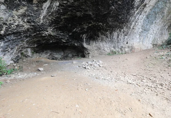 large cavern in the rock used by primitive men as a shelter during prehistory with blackened ceiling