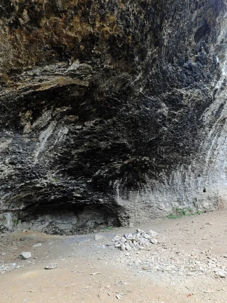 原始人が使っていた岩の中の大きな洞窟ですたき火の煙の黒い天井と先史時代の避難所として — ストック写真