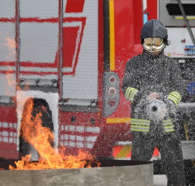 brave fireman with helmet during the extinguishing of a fire during the practical training test