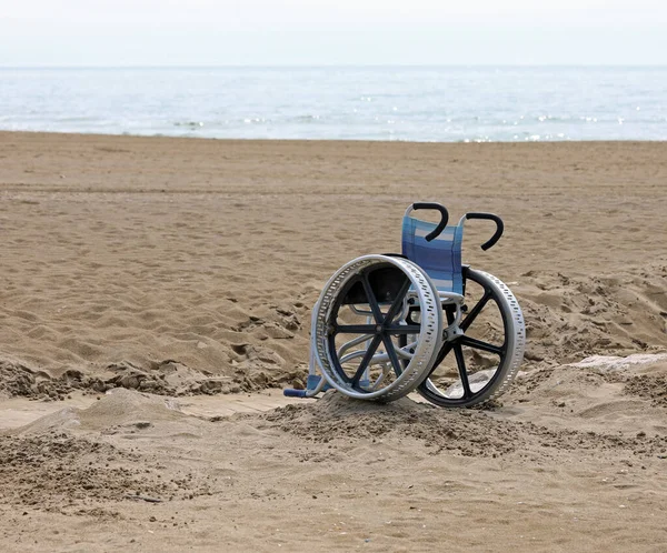 轮椅陷在海边的沙滩上 — 图库照片