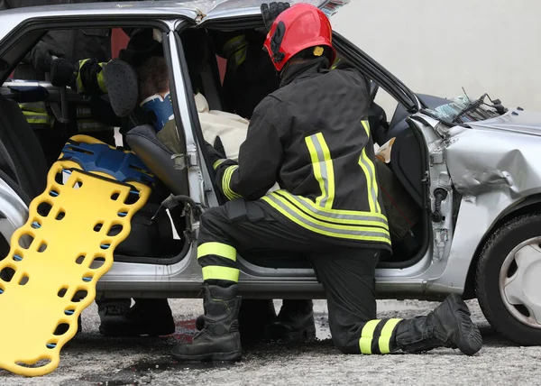 Yaralı kişiyle trafik kazası ve itfaiyeciyle birlikte sedye.