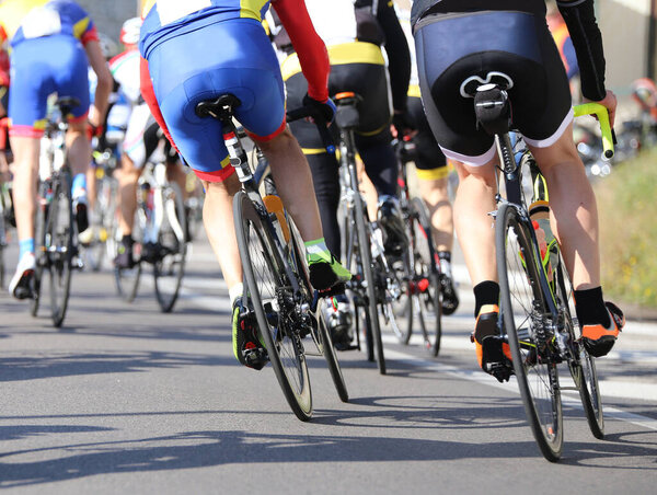 many cyclists pedal fast on the road during the cycling race