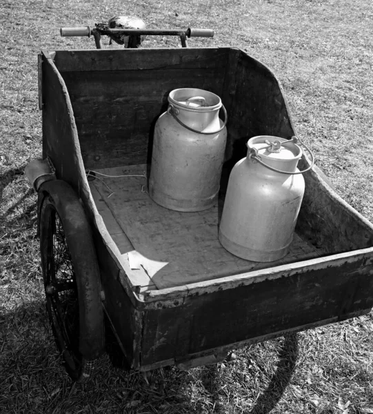 很久以前 一辆装有牛奶罐的自行车从送牛奶的人那里经过 用来运送具有黑白效果的鲜牛奶 — 图库照片