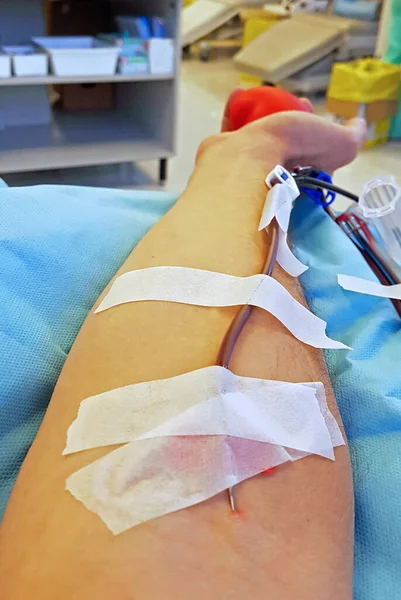 Arm of a volunteer Blood donor with surgical needle at the hospital