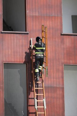 İdman sırasında itfaiye merdiveninde itfaiyeci vardı.