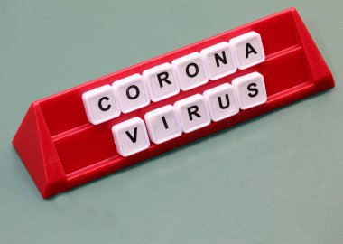 Pano oyunu sırasında kırmızı bir kürsüde plastik fayanslarla yapılmış Coronavirus metni